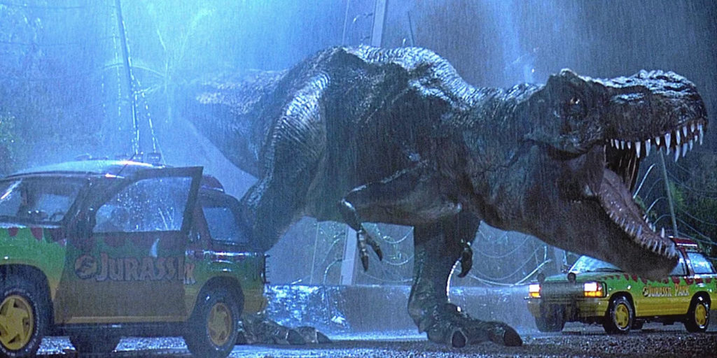 The T. rex roars in the rain next to a destroyed tour Jeep in Jurassic Park (1993)