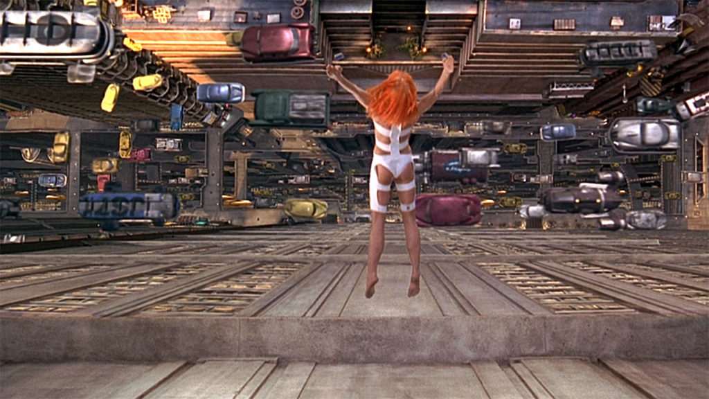 Leeloo dives through midair into a futuristic taxi driven by Korben Dallas in The Fifth Element (1997)