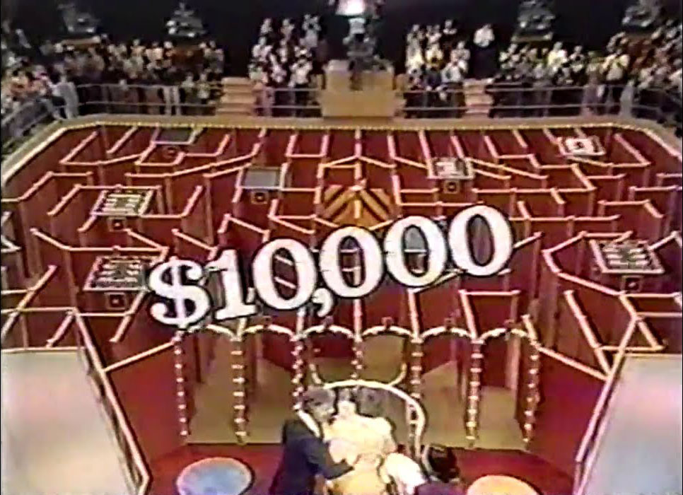 A contestant running through life-sized maze on The Money Maze