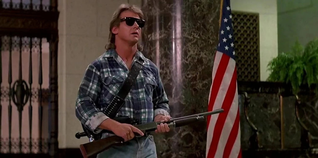 Cult Classics You Should Finally Watch - Roddy Piper wearing sunglasses in a scene from They Live (1988)