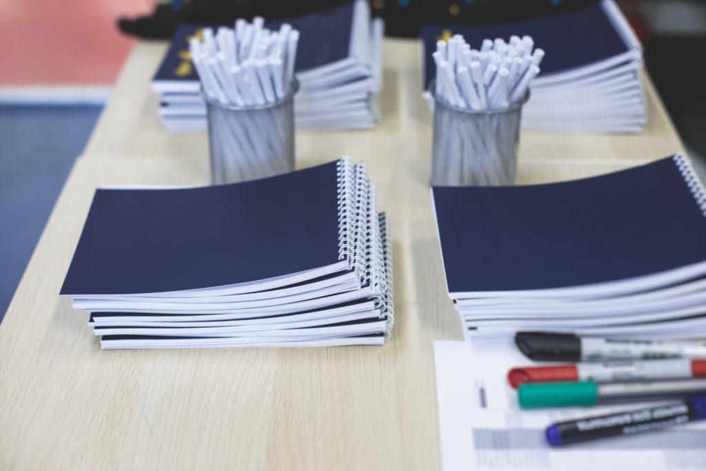 How to Play Telephone Pictionary - Paper and notebooks prepared for a game of Telephone Pictionary