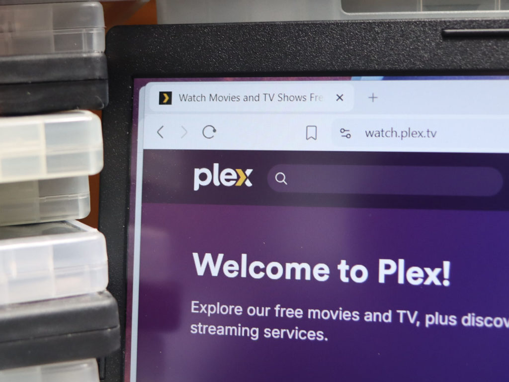 building a Plex server - stack of physical media next to a device running the Plex media server app.