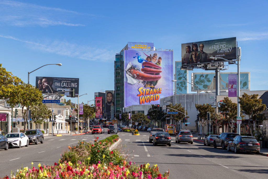 What Makes a Movie a Box Office Bomb The Real Math - A large Hollywood movie promotional billboard displayed over a busy city street
