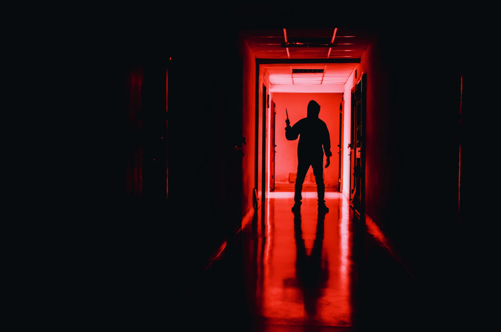 how to host a horror movie marathon - A slasher stands at the end of a hallway
